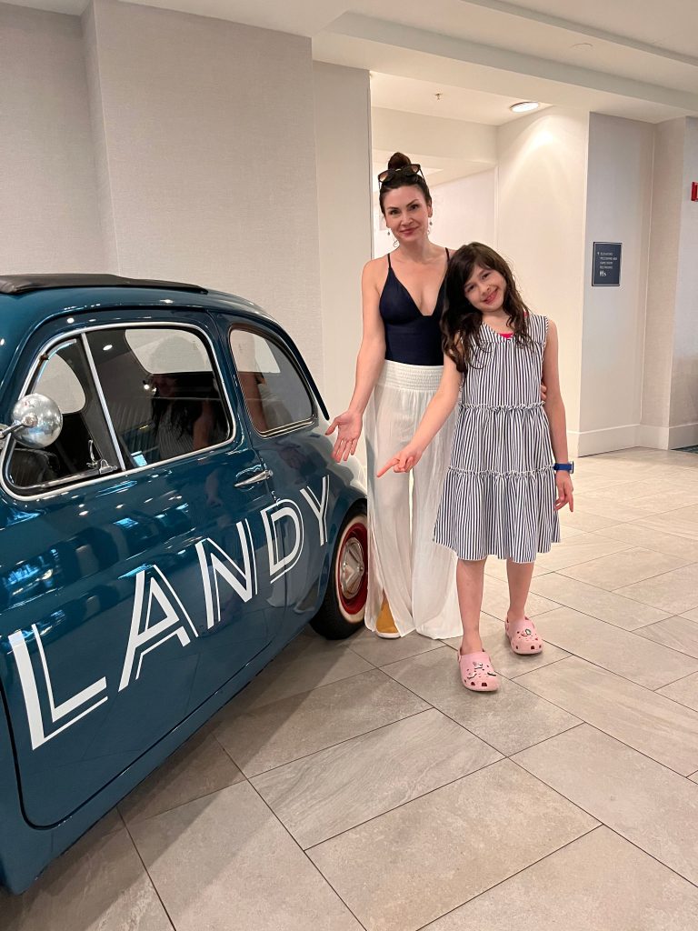 The lobby of Hotel Landy with the miniature teal car that says "Landy."